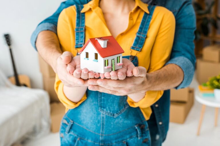 A house toy on a couple's hands in the concept of relocating to Twickenham.