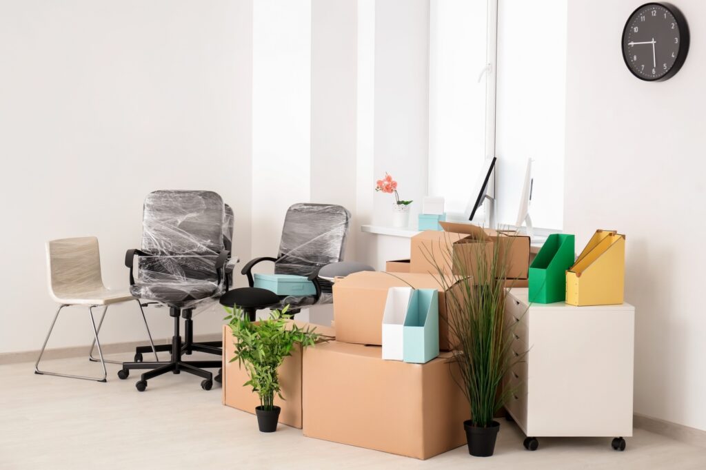 Wrapped chairs, moving boxes, and other office items at the office corner in the concept of 'What Are the Factors Influencing the Cost of Office Removals in Twickenham?'